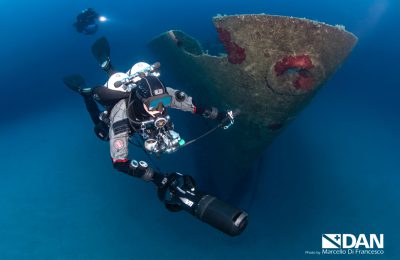 Subacqueo tecnico con scooter esplora il relitto Um El Faroud a Malta durante un'immersione profonda in acque cristalline