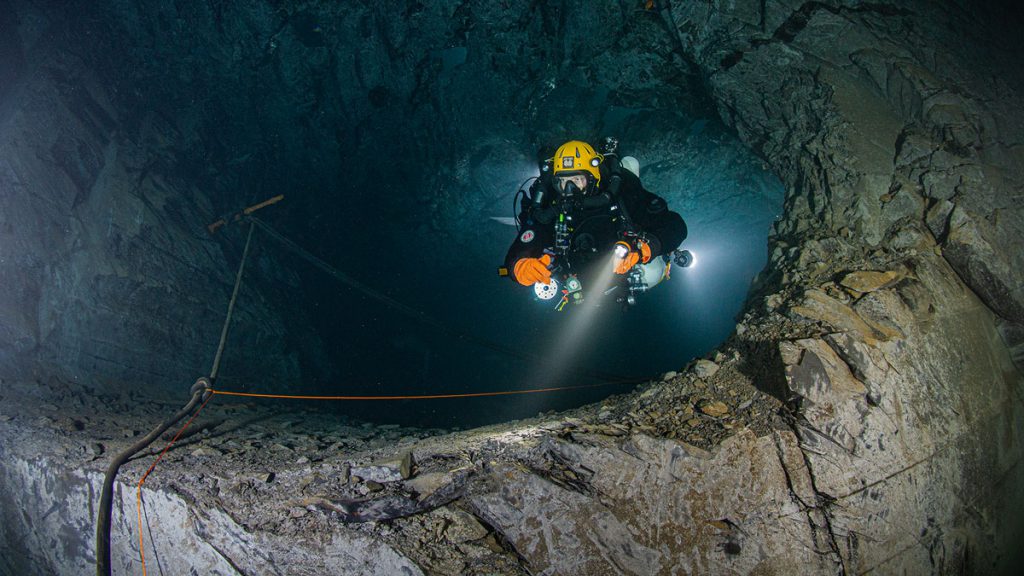 Subacqueo tecnico che attraversa una porta all’interno della miniera di ardesia allagata di Nuttlar in Germania