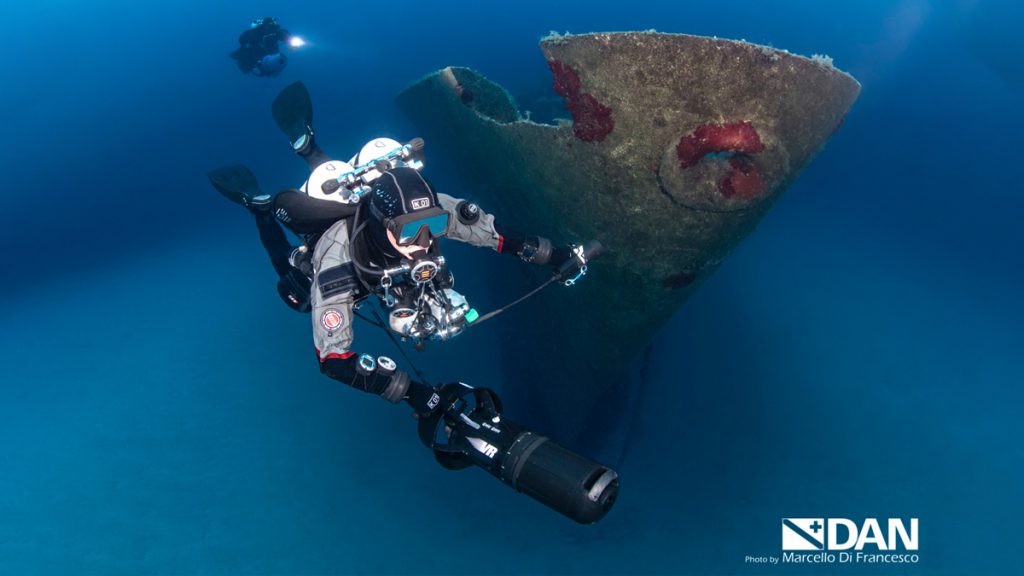 Subacqueo tecnico con scooter esplora il relitto Um El Faroud a Malta durante un'immersione profonda in acque cristalline