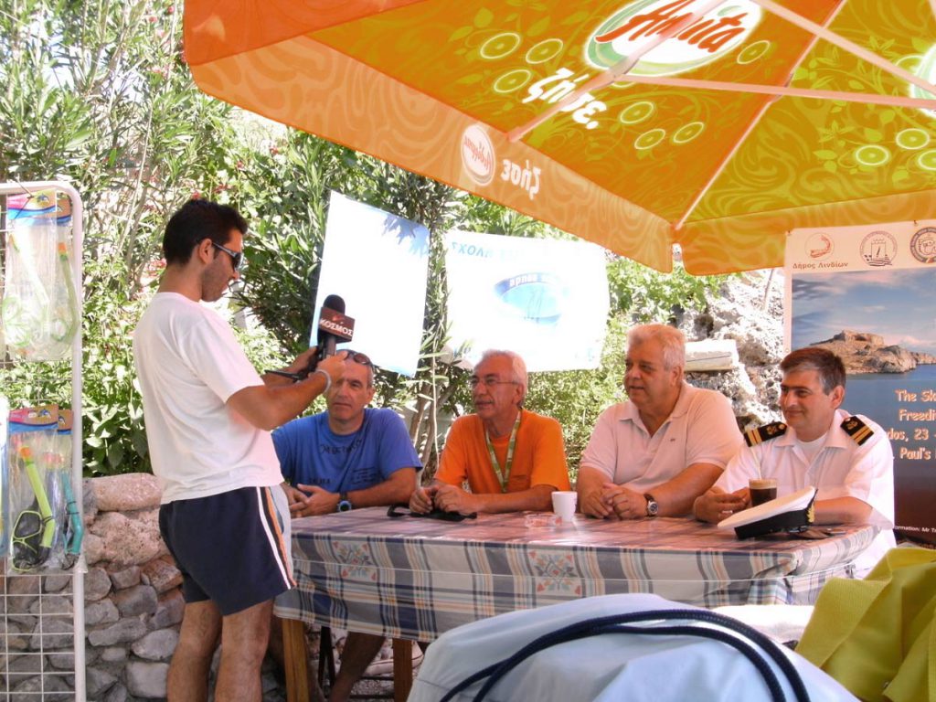 Nikolas Trikilis e altri relatori durante una conferenza stampa su un evento di skandalopetra in Grecia