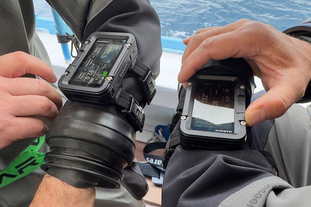 Due subacquei mostrano gli schermi dei loro computer da polso Garmin Descent X50i