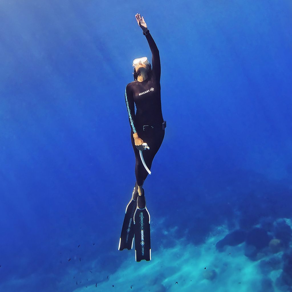 Ilaria Molinari che pratica apnea in acque blu profonde.