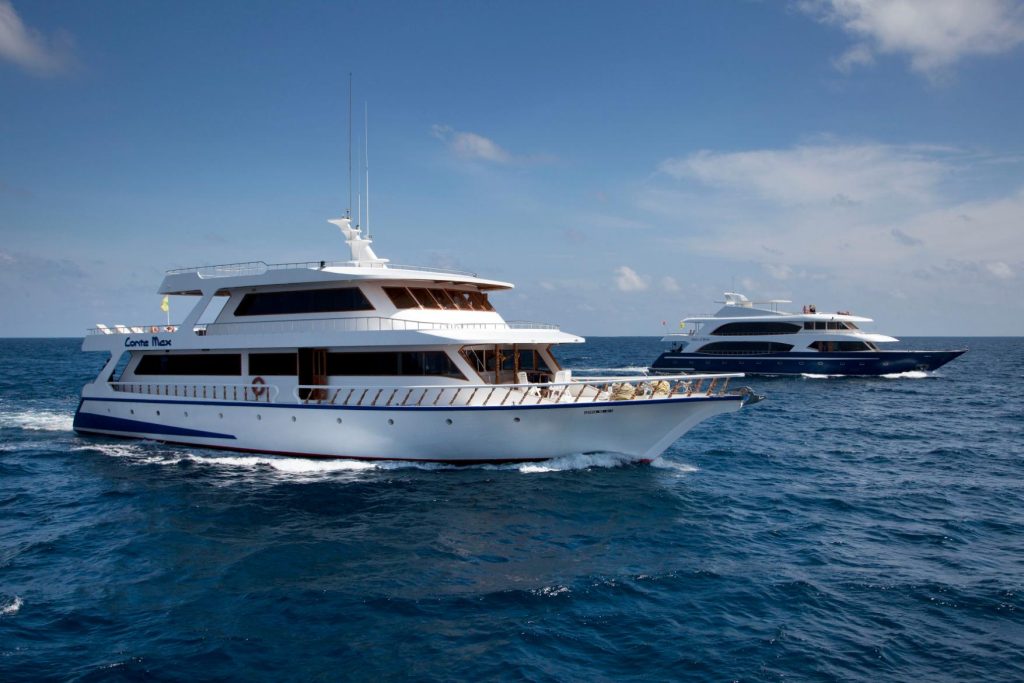 Due barche da crociera subacquea in navigazione alle Maldive.
