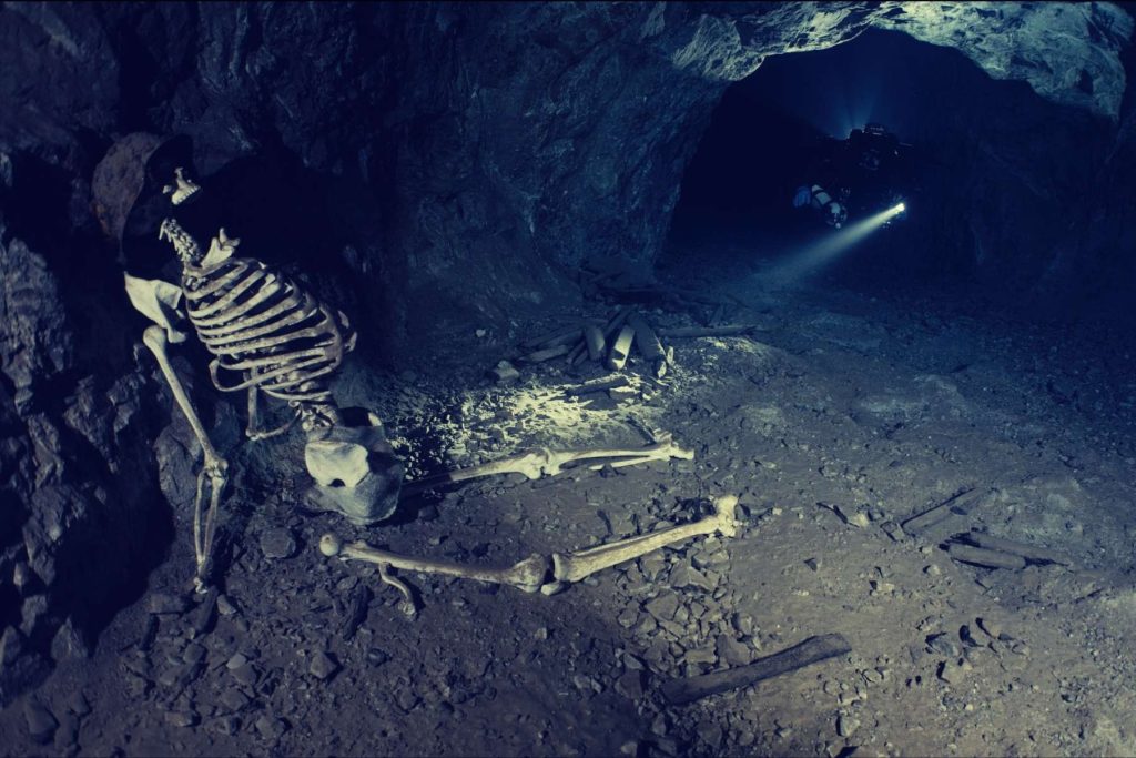 Subacqueo in una miniera allagata accanto a uno scheletro nel documentario Hidden Worlds