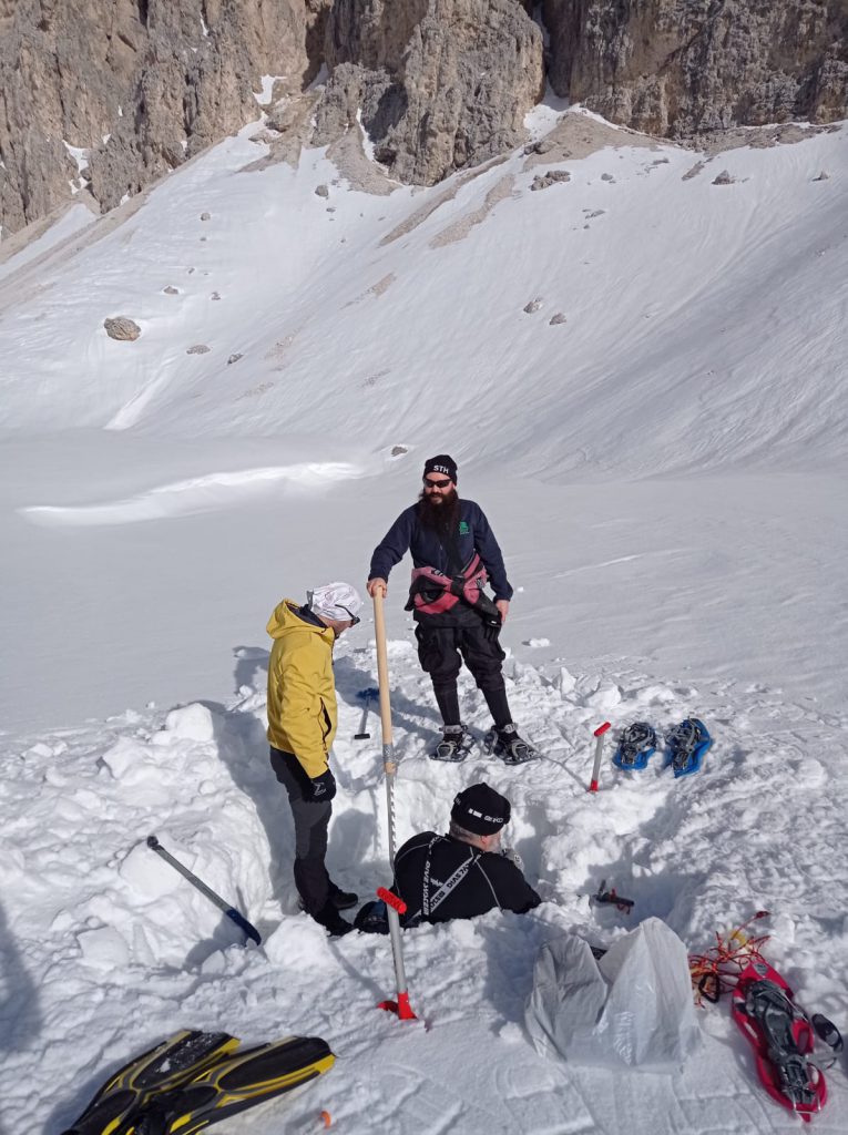 Scavo nella neve sul Lago di Antermoia per raggiungere la lastra di ghiaccio durante la spedizione invernale
